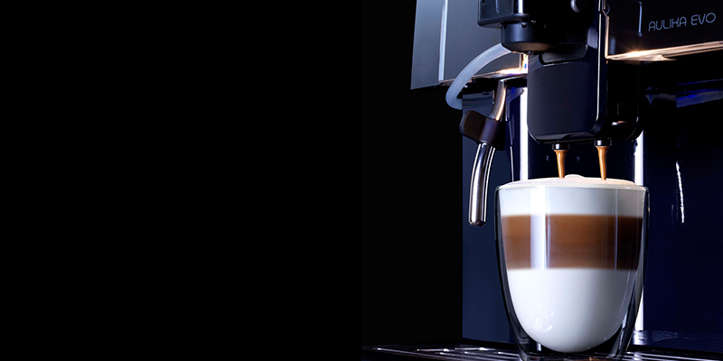 Machine à café professionnelle en train de servir un cappuccino But First Coffee